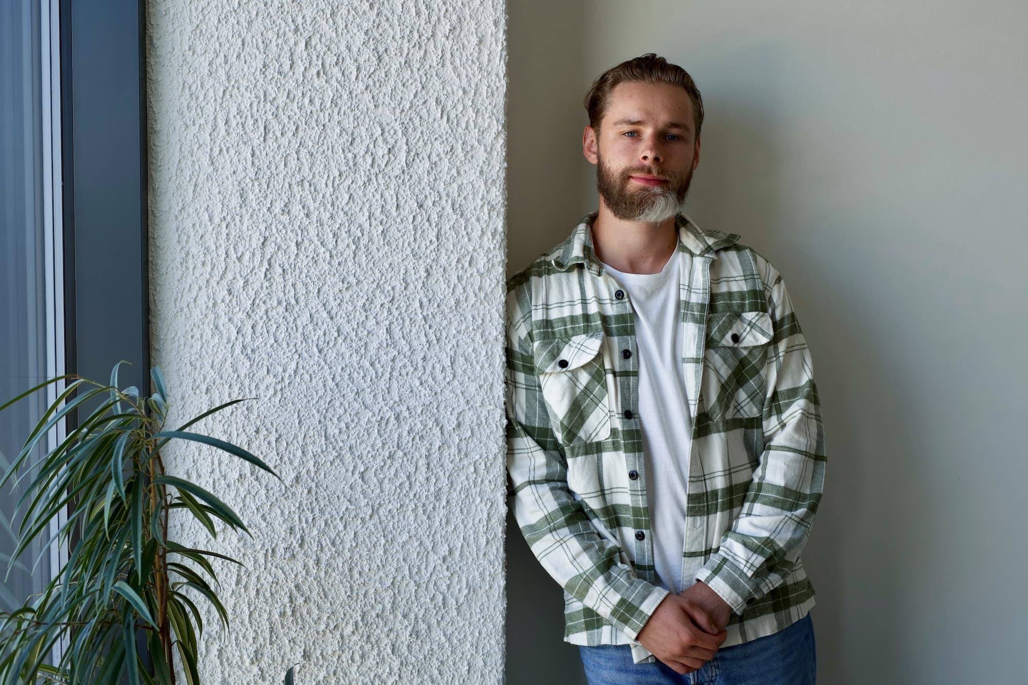 Software engineer Andrej leaning casually against the wall, taking time to reflect