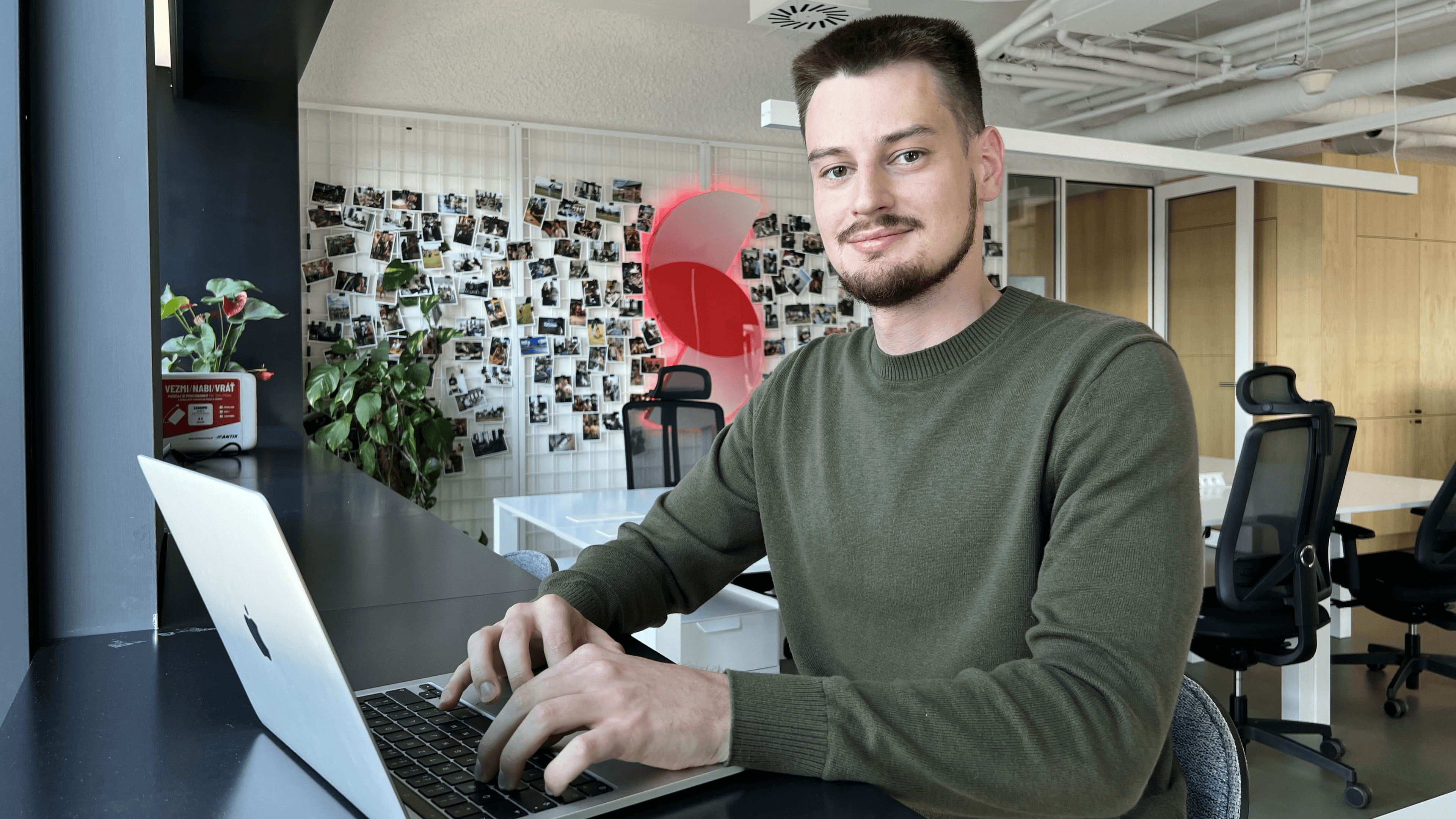 Jakub working on a computer at the office, focusing on an innovative AI project