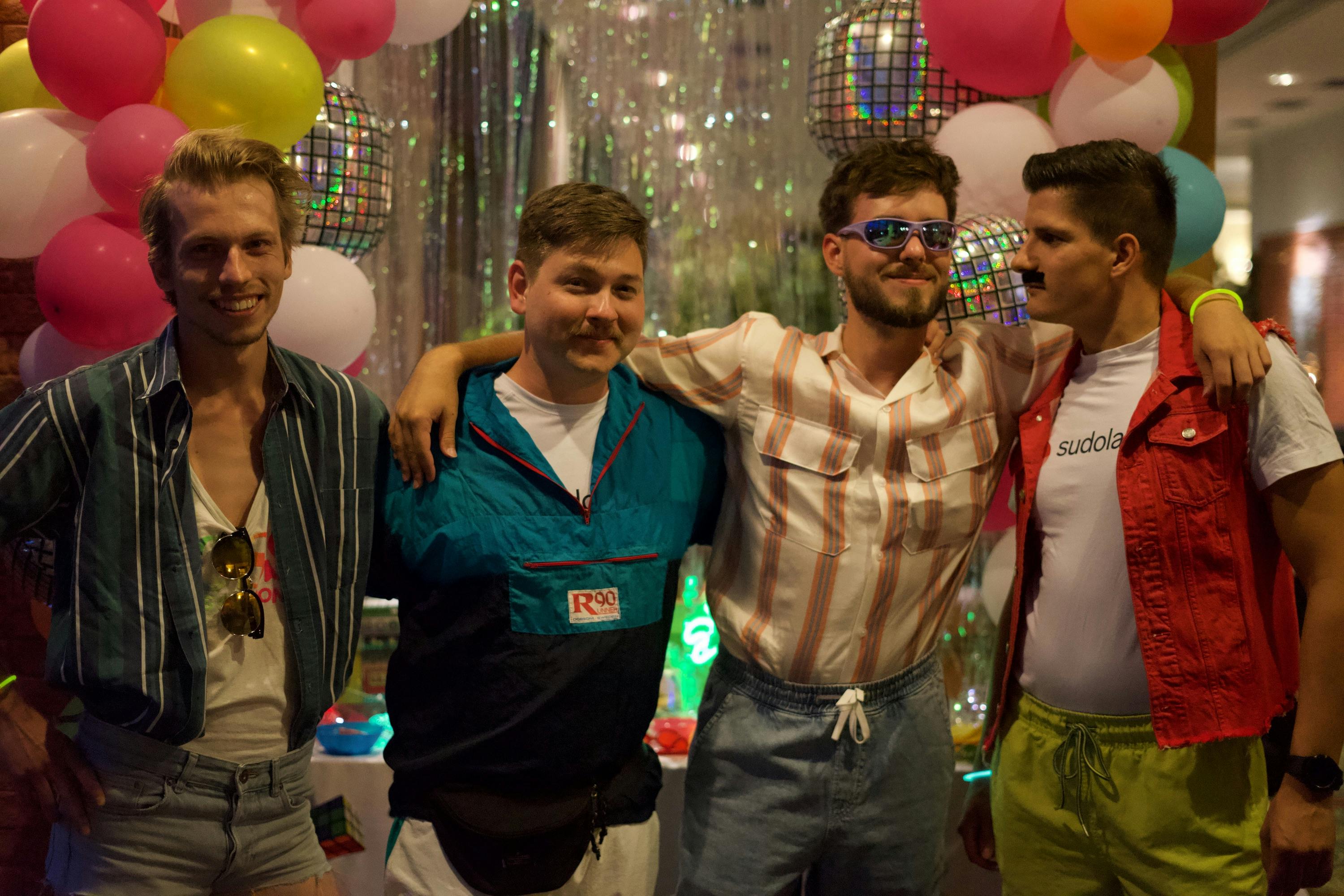 Richard, Ivan, Jozef and Jozi posing for a picture in 80s style clothes